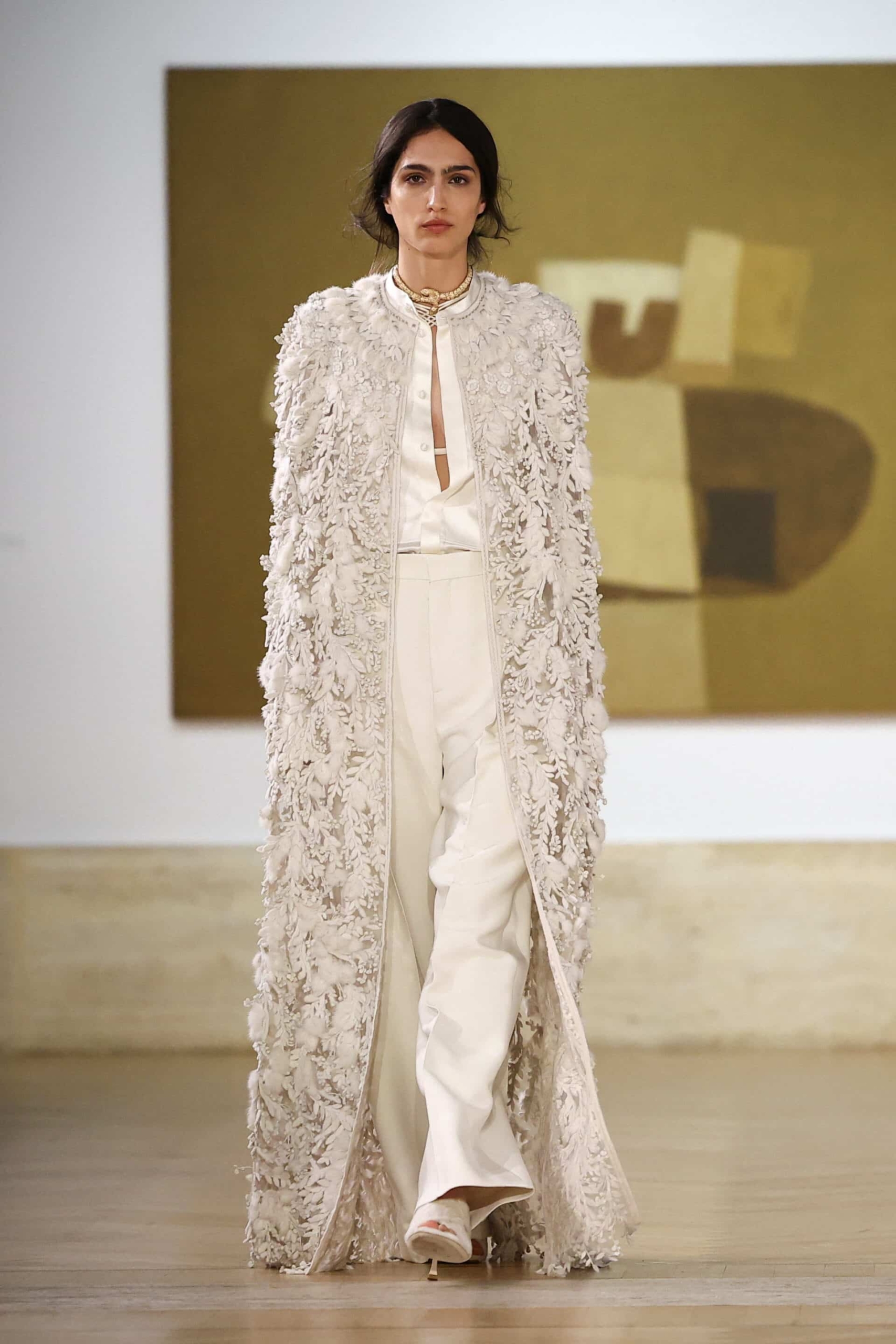 look bridal da Fendi alta-costura inverno 2026 com calças de alfaiataria, blusa de seda e casaco longo bordado com aplicações florais tridimensionais